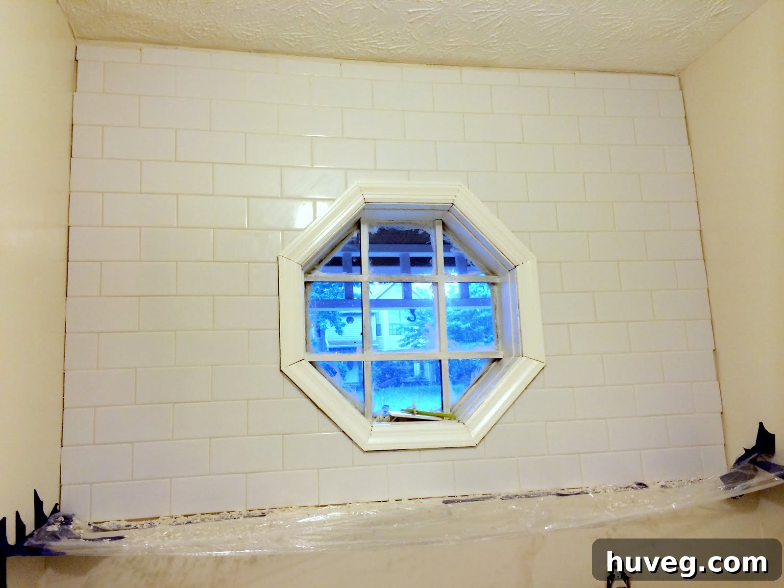 Temporary protective barrier over washer and dryer during tiling to prevent grout mess and spills