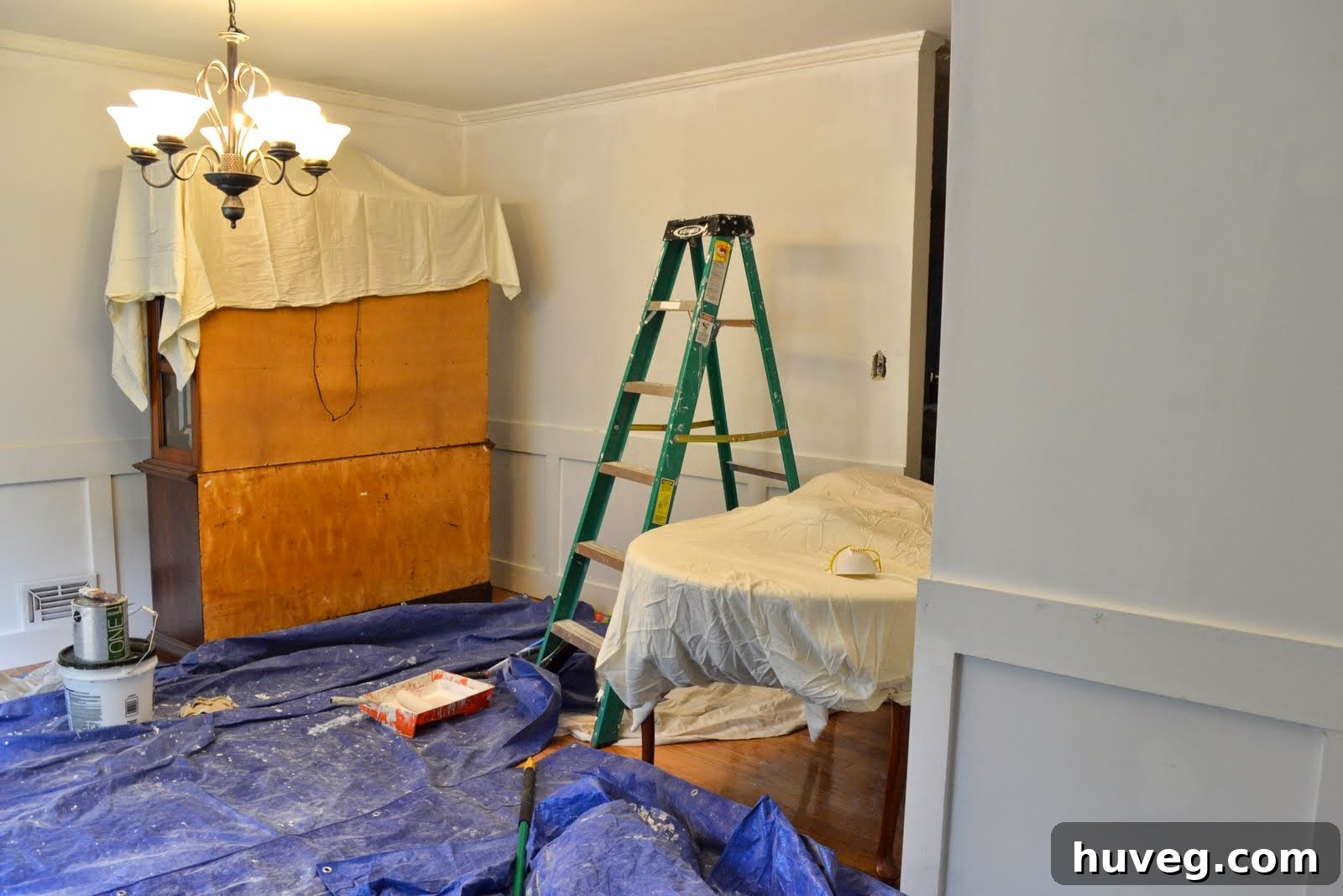 The dining room prepped for painting, with floors and furniture covered to protect against spills