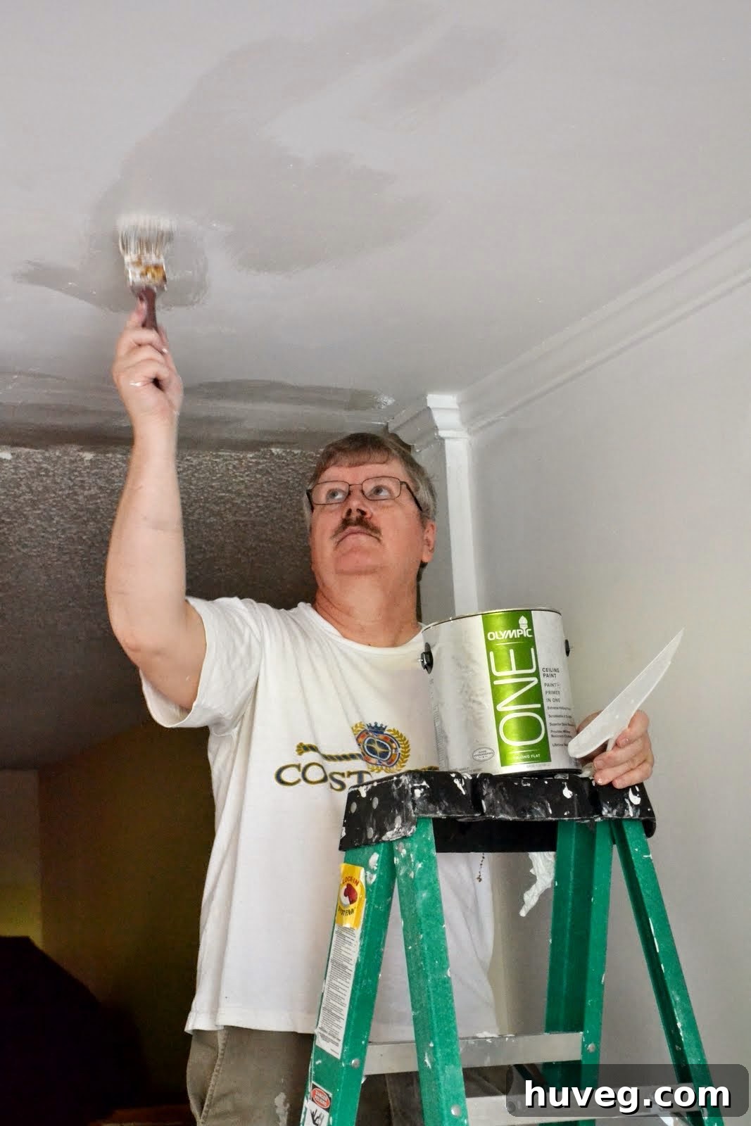 Dad on a ladder, diligently painting the ceiling with white Olympic One paint