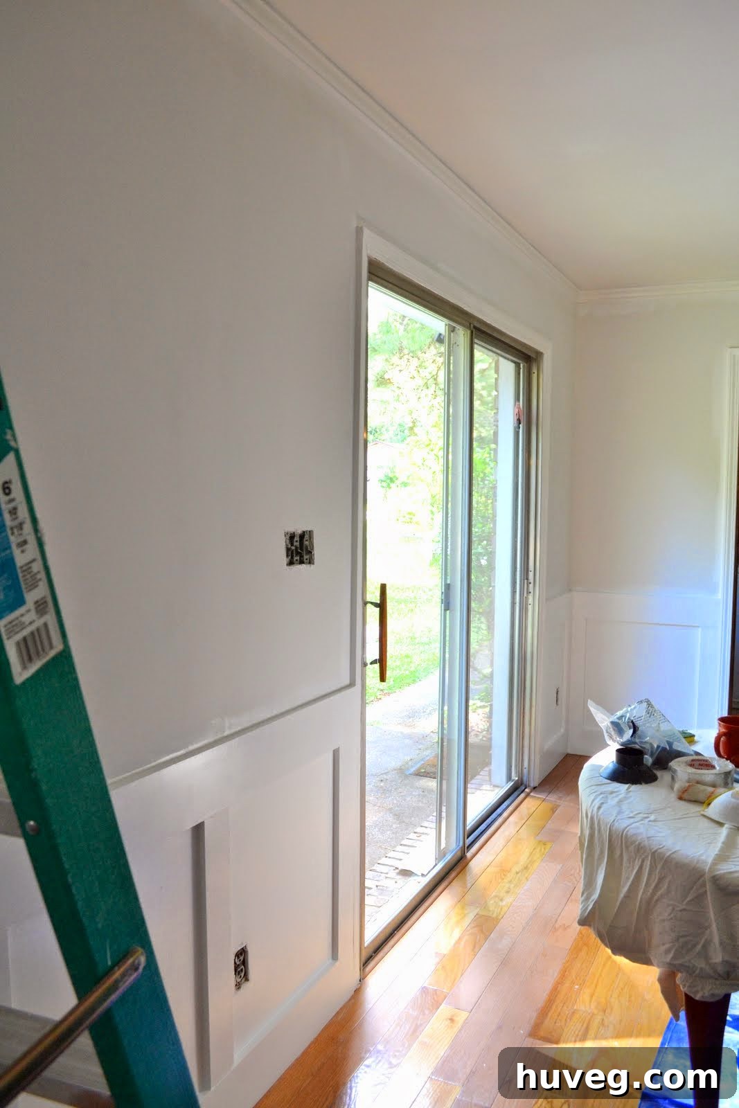 A view of the dining room with all white elements (ceiling, wainscoting) fully painted and dry