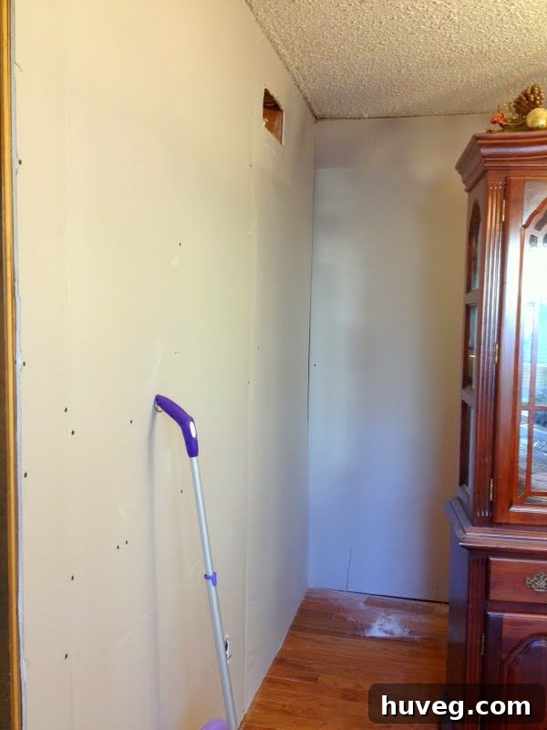 Freshly hung drywall panels covering old wood paneling, before taping and mudding