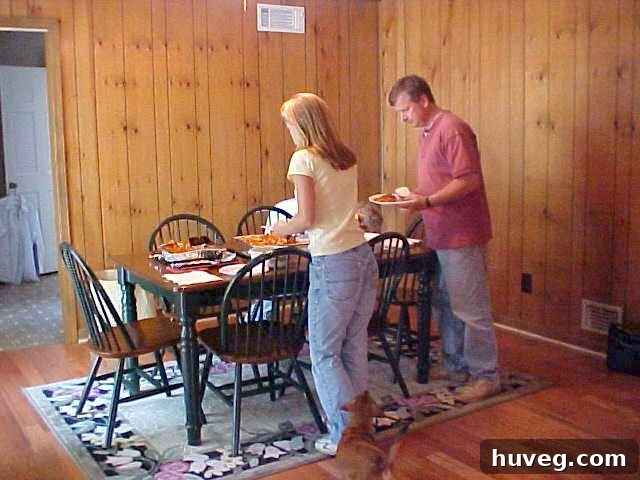 Original dining room featuring outdated wood paneling and a young me