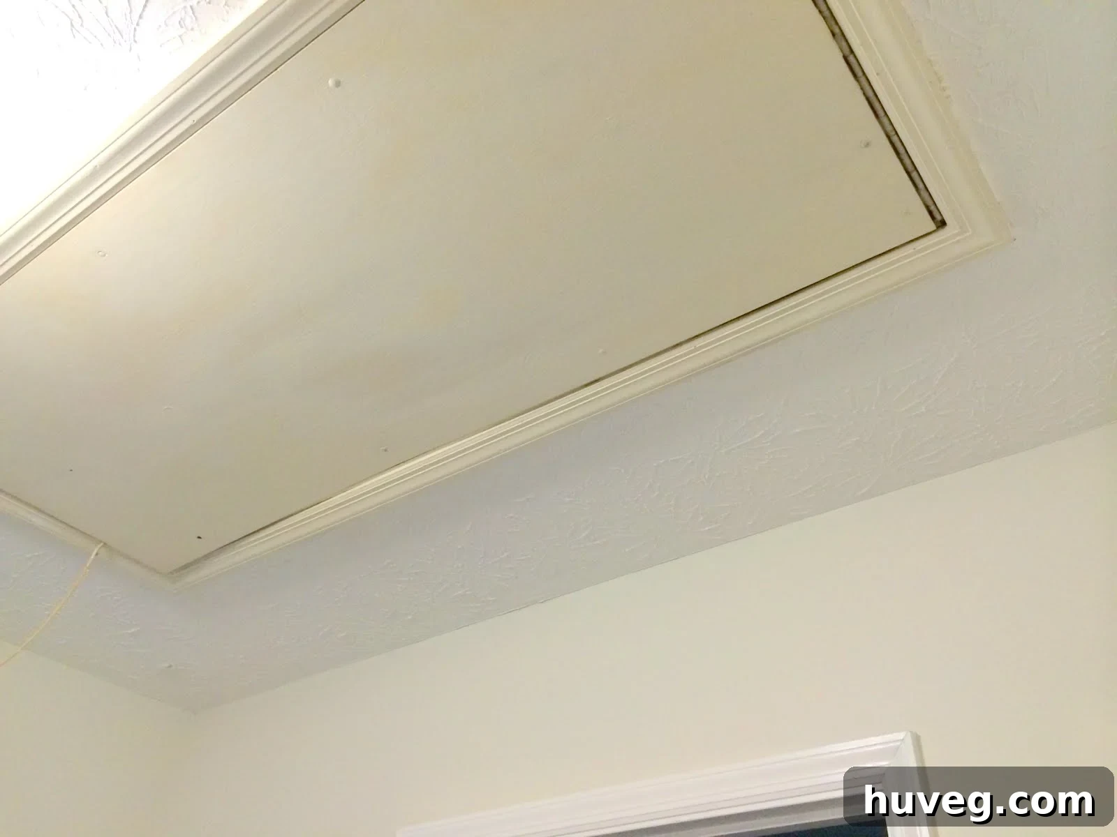 Unpainted attic access panel in hallway