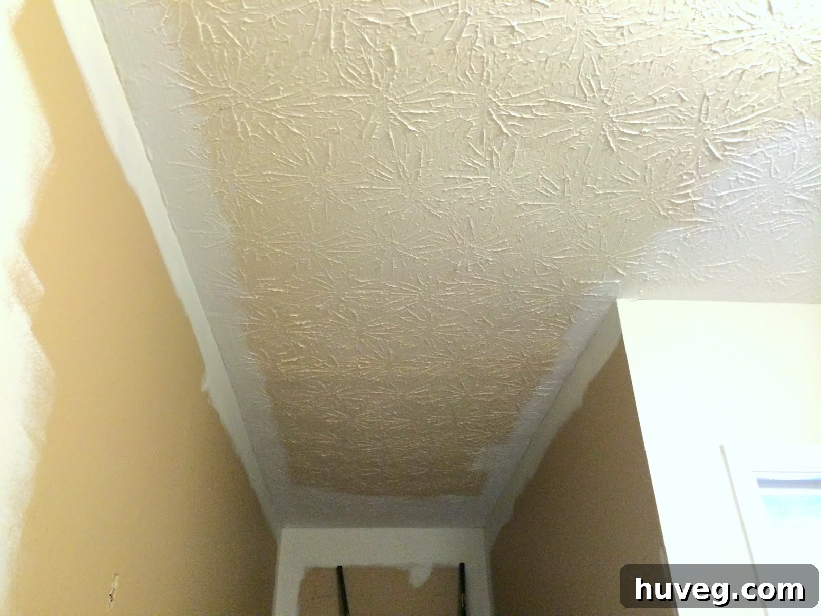 Stairway hallway with various paint colors before painting ceiling