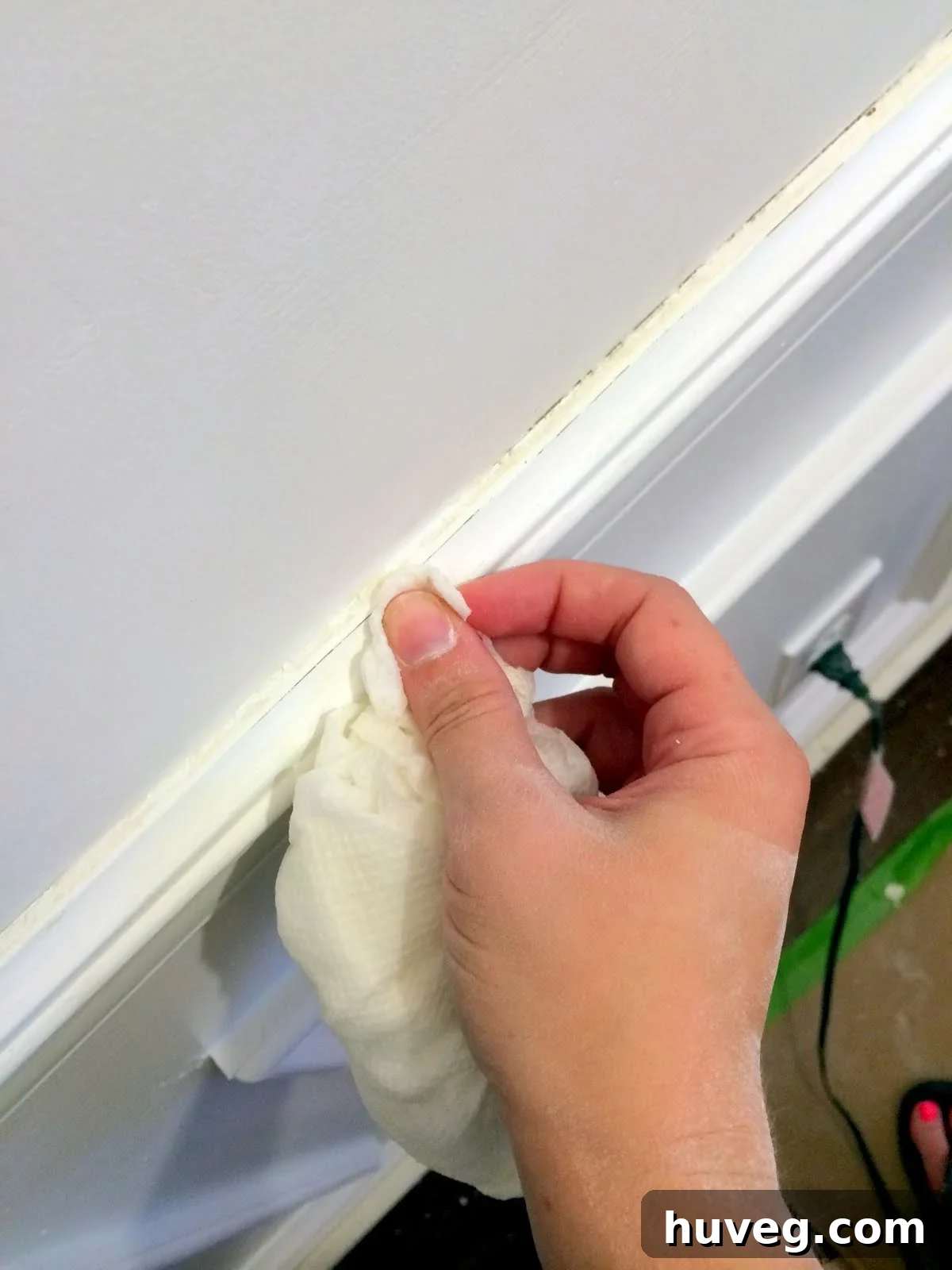 Detailed shot of chair rail being cleaned of dried joint compound and dust