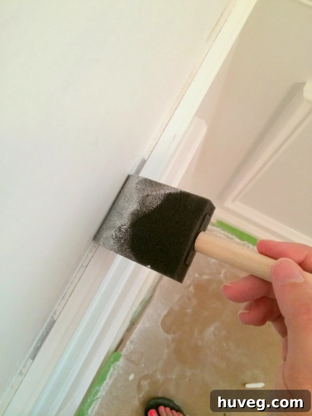 Foam brush being used to touch up a spot on the trim with primer