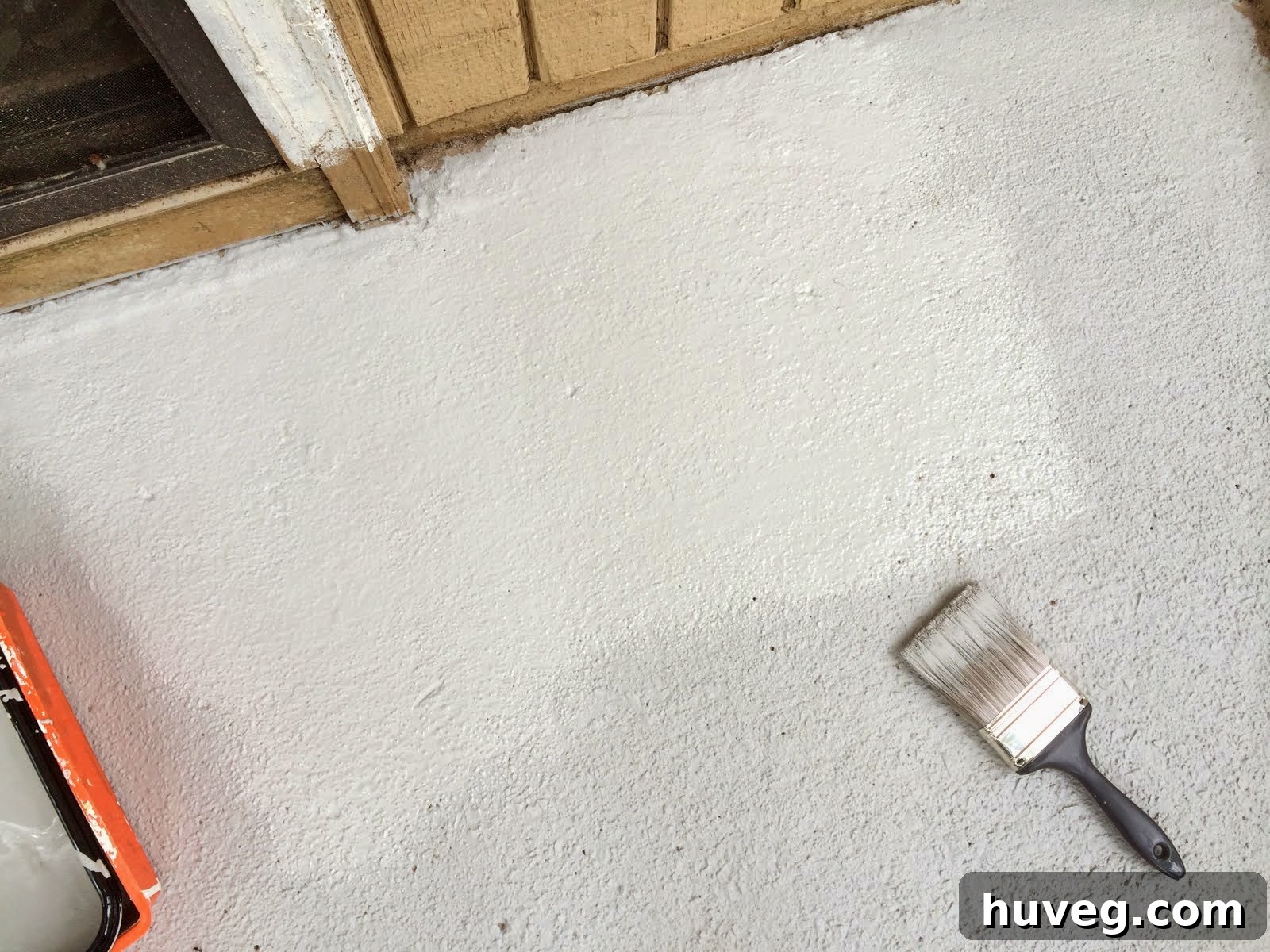 Applying the second coat of concrete resurfacer to the patio