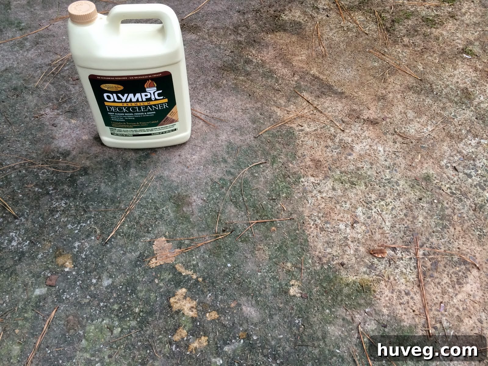 Olympic Premium Deck Cleaner bottle on a dirty concrete patio