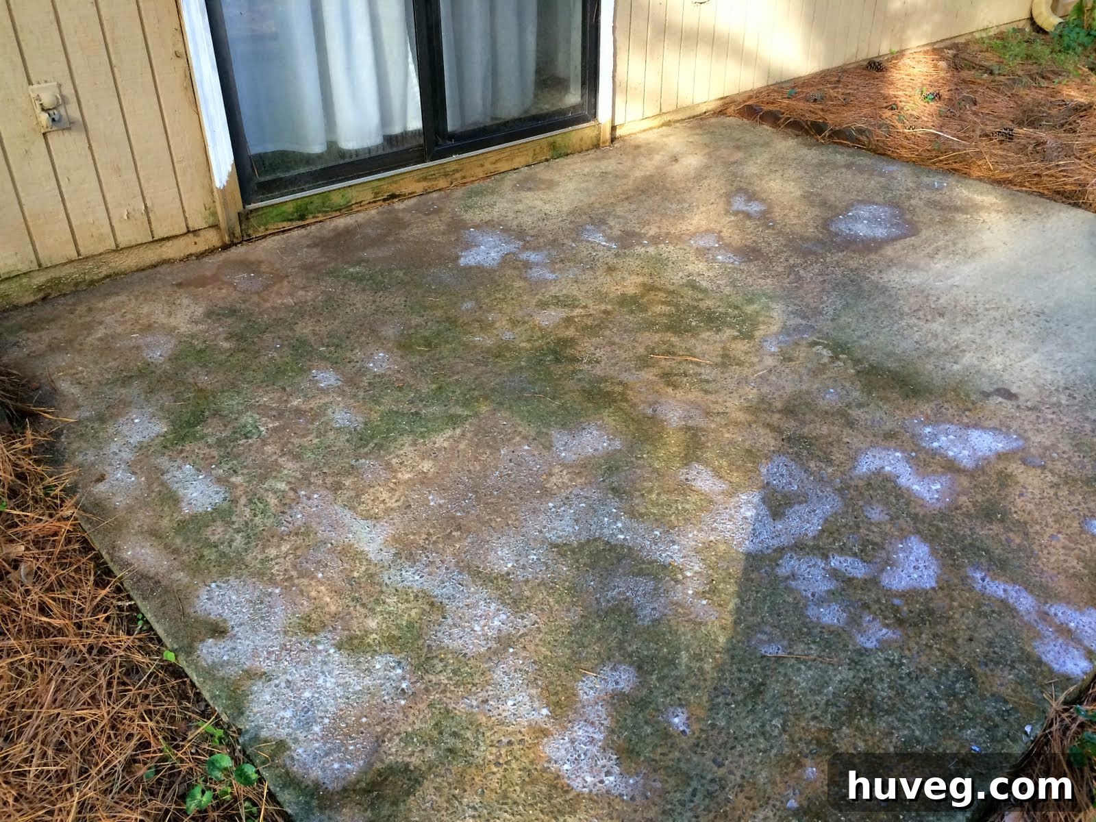 Close-up of patio showing cleaner working, with white foam and residue