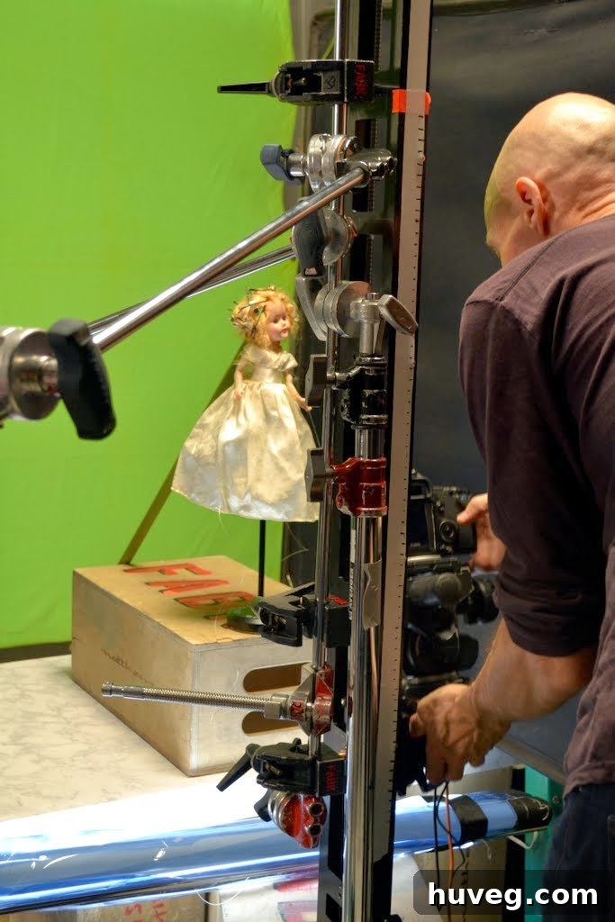 Cameraman photographing a doll in front of a greenscreen