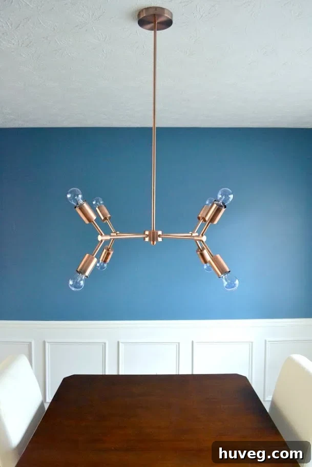 Full view of the dining room with the elegant copper chandelier as the central focal point