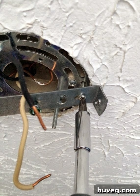 Installation progress of the new copper light fixture, showing adjusted rod length and wiring