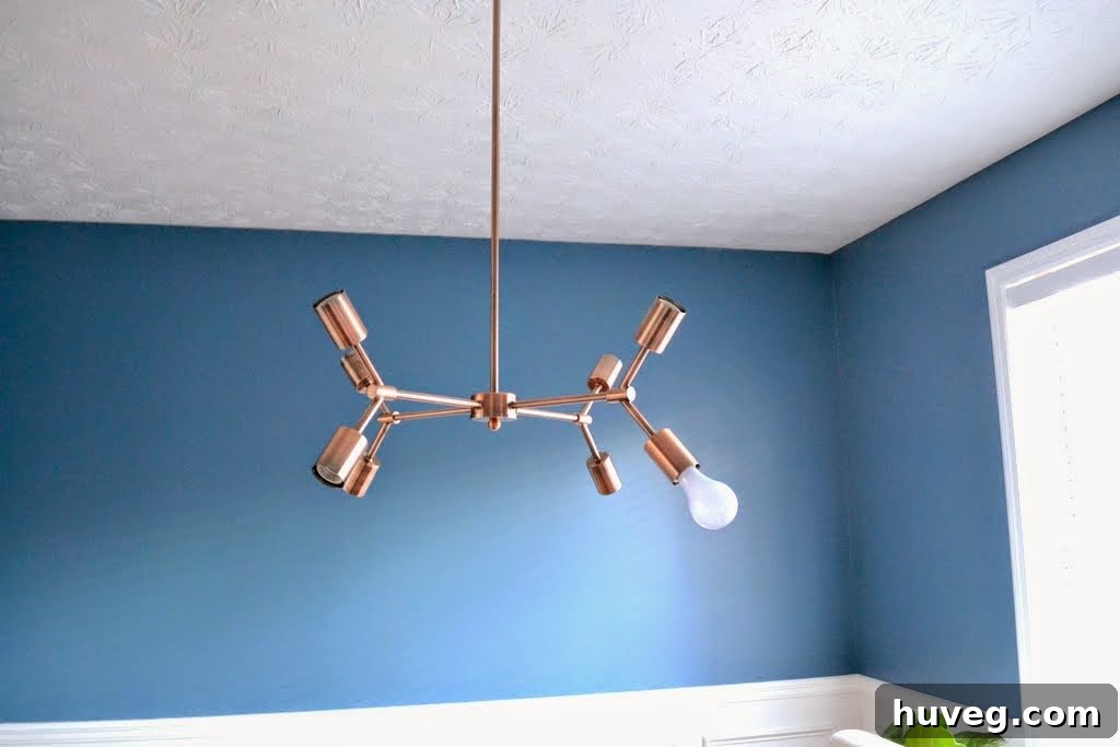 Humorous photo of a single temporary light bulb hanging from the new copper fixture during testing