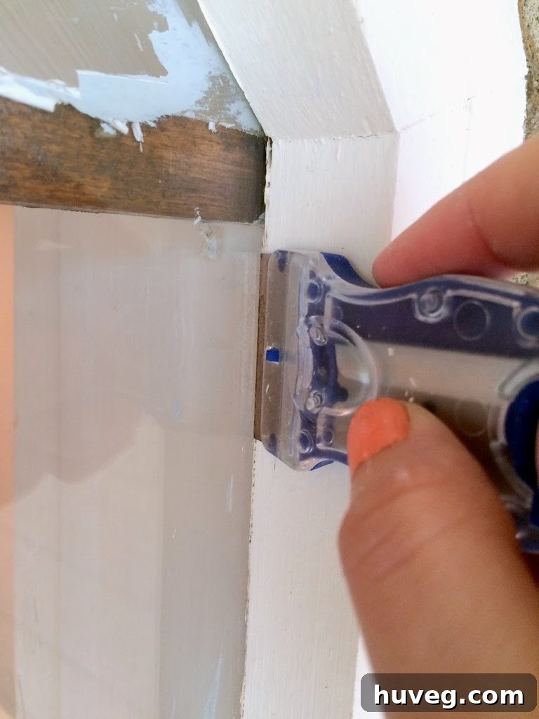 Cleaning up window edges with a scraper at a 90-degree angle