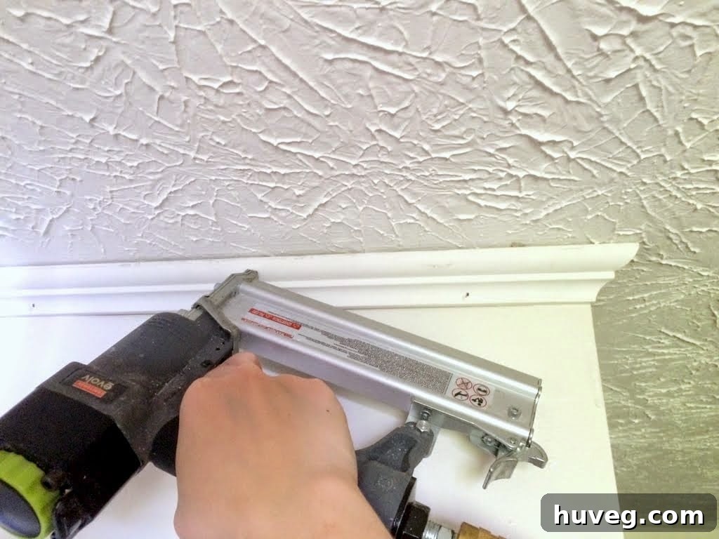 Crown molding installation progress and shelf planning with blue tape