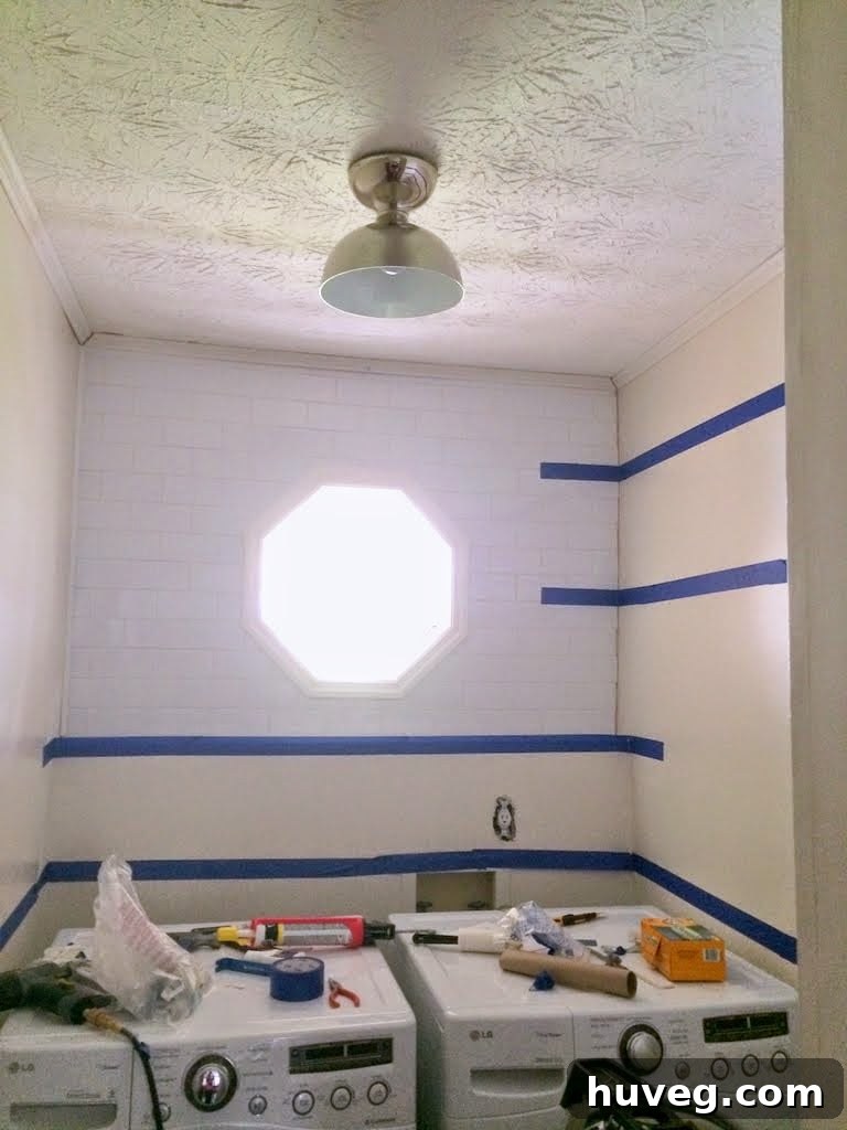 Finalized shelf placement plan using blue tape in laundry room