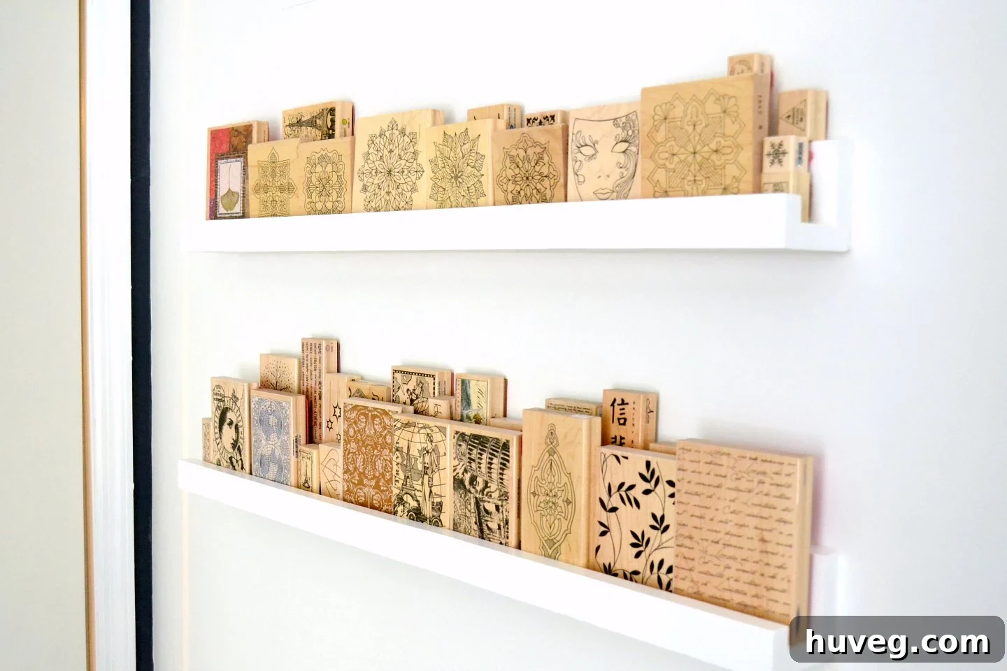 Organized wood stamp collection on DIY office ledges, utilizing vertical space behind a door for efficient storage.