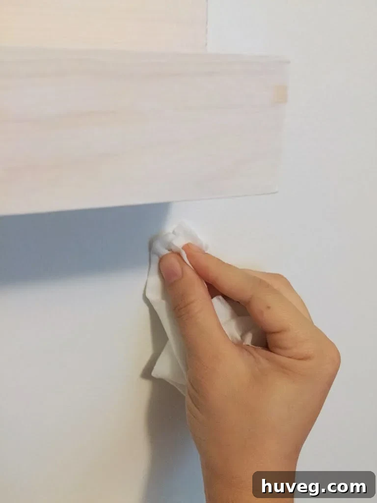 A makeup wipe used to effortlessly erase pencil marks from a freshly painted wall after shelf installation.