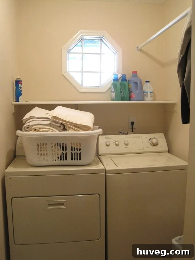 Before photo of a cluttered laundry room with a traditional shelf over the washer and dryer.