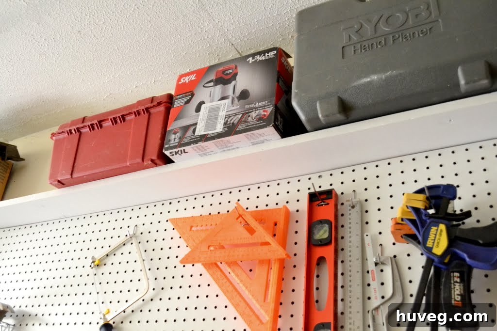 Top shelf of pegboard wall showcasing tool cases and boxes