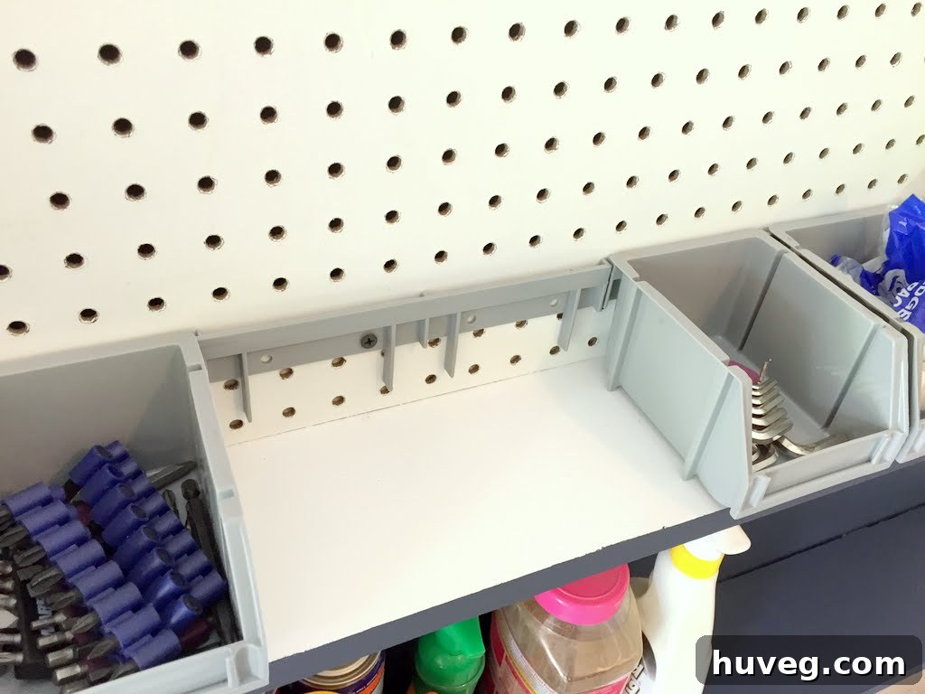 Rail and small gray bins installed on the pegboard