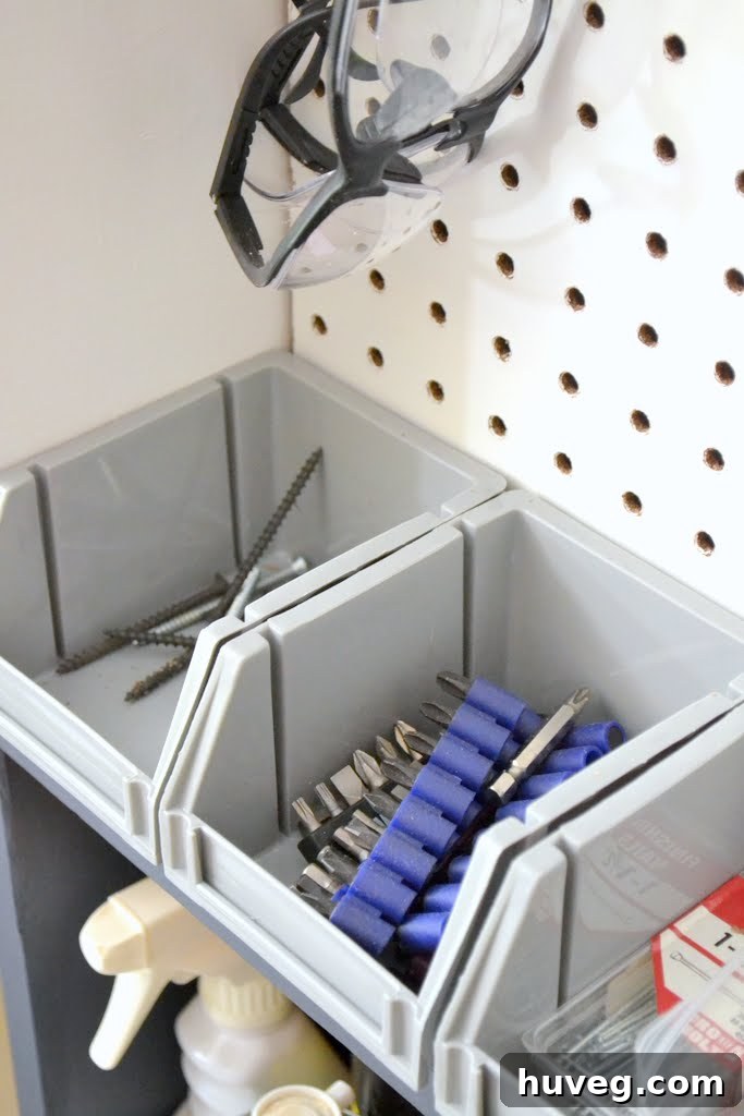 Close-up of bits and screws neatly stored in a small gray bin
