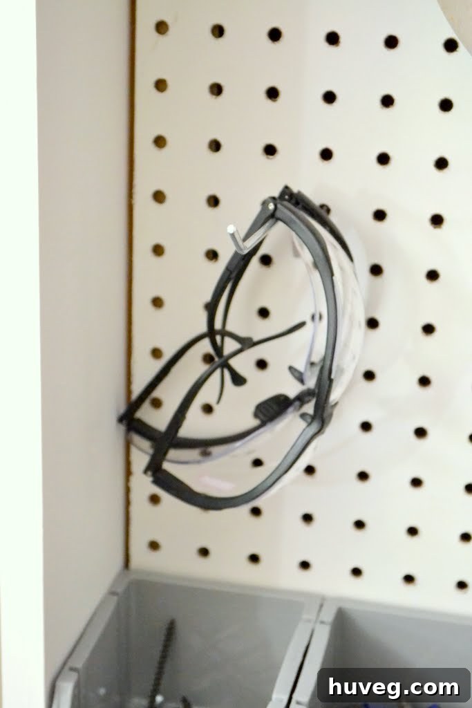 Hanging safety goggles on pegboard hooks for easy access