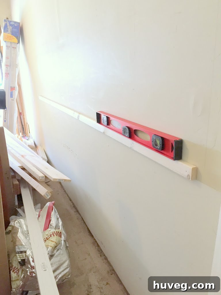 Cleat installed on wall with a level to ensure straightness