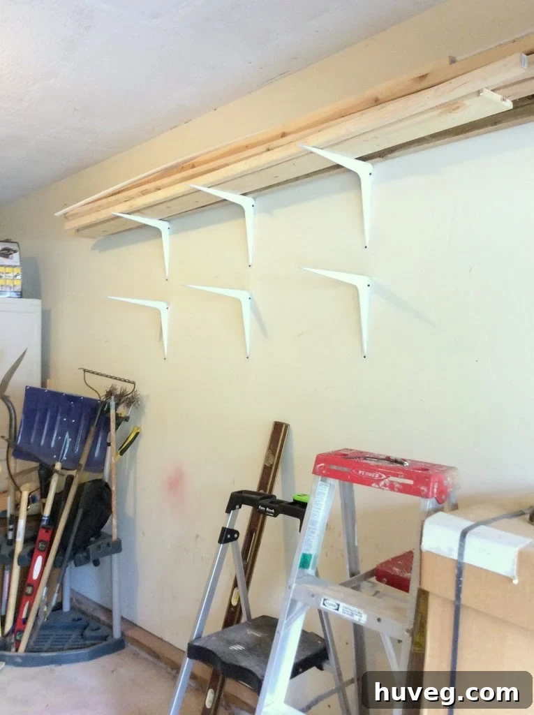 DIY lumber storage rack setup with painted shelf brackets