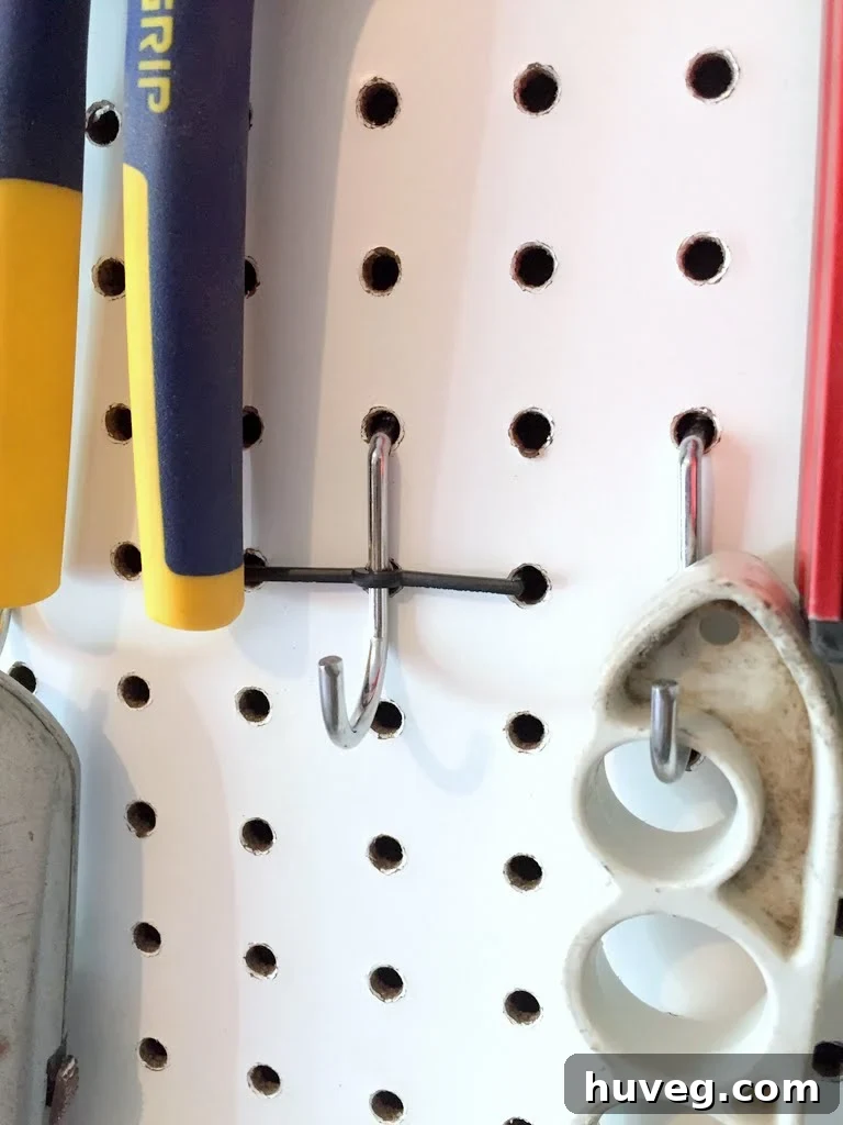 Installed pegboard hook with the plastic locking clip visible