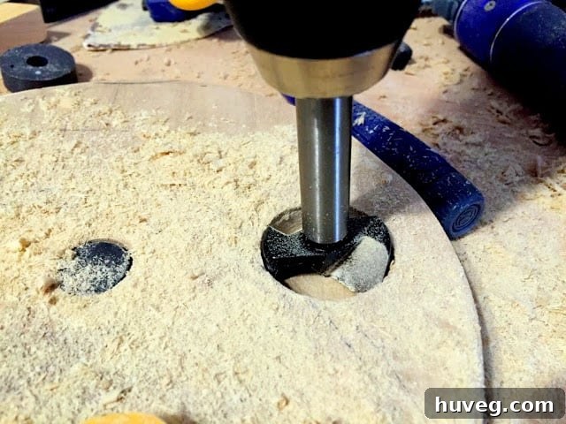 Forstner bit in action, drilling a precise, flat-bottomed hole into a round wooden piece.