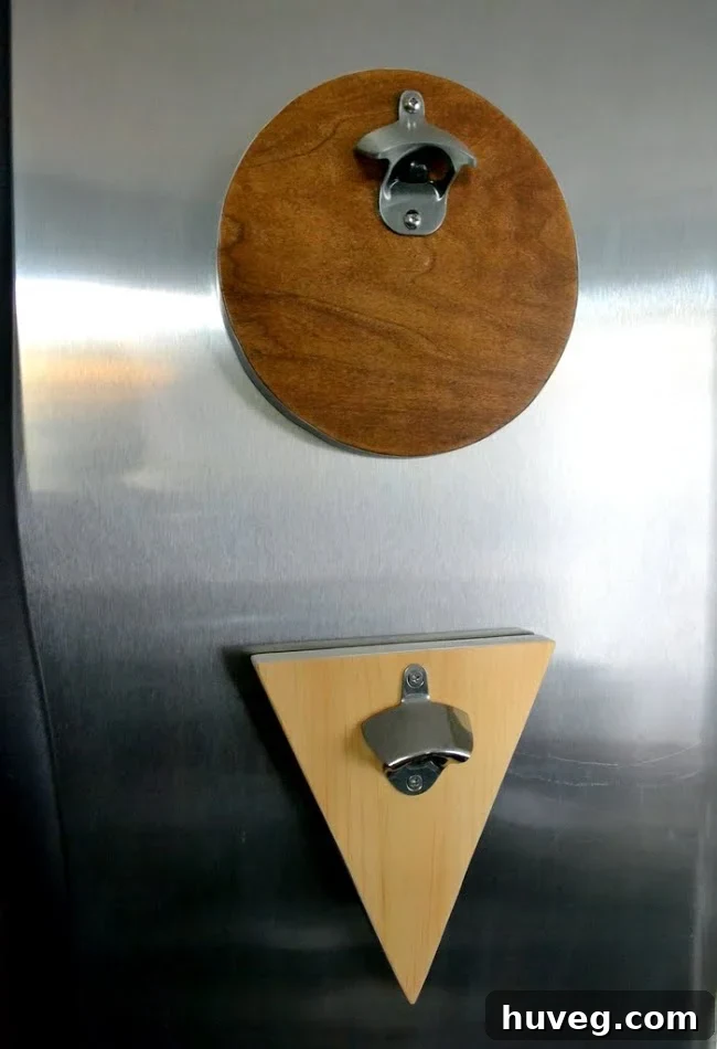 Two finished scrap wood magnetic bottle openers, one round and one triangular, displayed on a refrigerator.