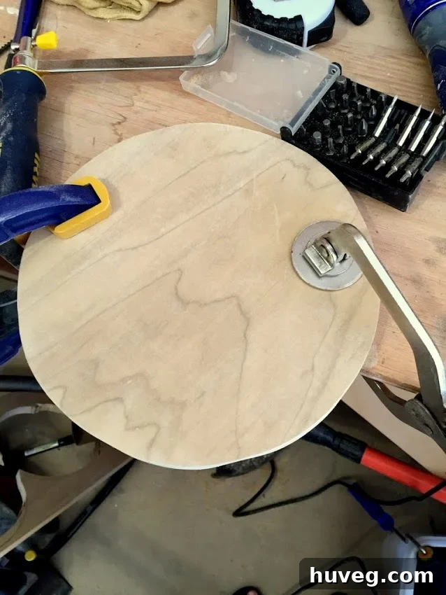 Roughly cut round wood shape clamped to a workbench, ready for refining.