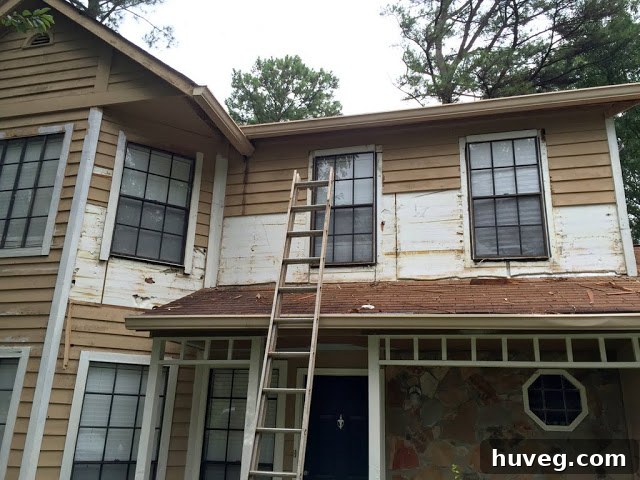 Close-up of exterior home renovation in progress, showing exposed wall studs after siding removal