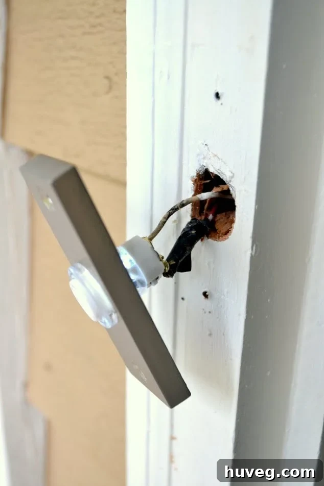 I connected the wires on the back of the new nickel finish doorbell and drilled two holes for the screws that would attach the plate