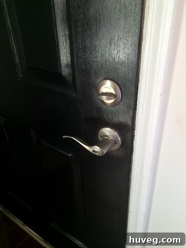 New front door handle and deadbolt installed, showcasing brushed nickel finish.