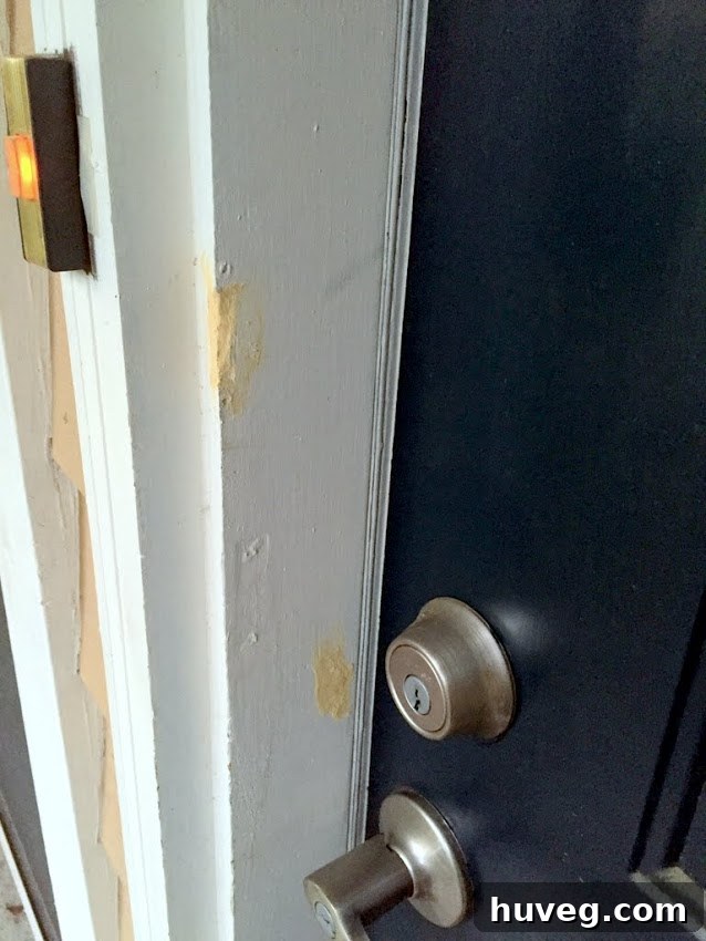 Repaired door trim with wood putty and fresh paint, completing the detail work.