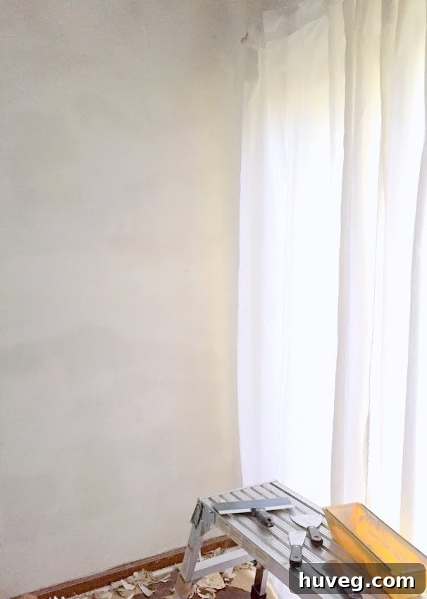 Close-up of a kitchen wall undergoing renovation, possibly showing a smooth skim coat or primer application