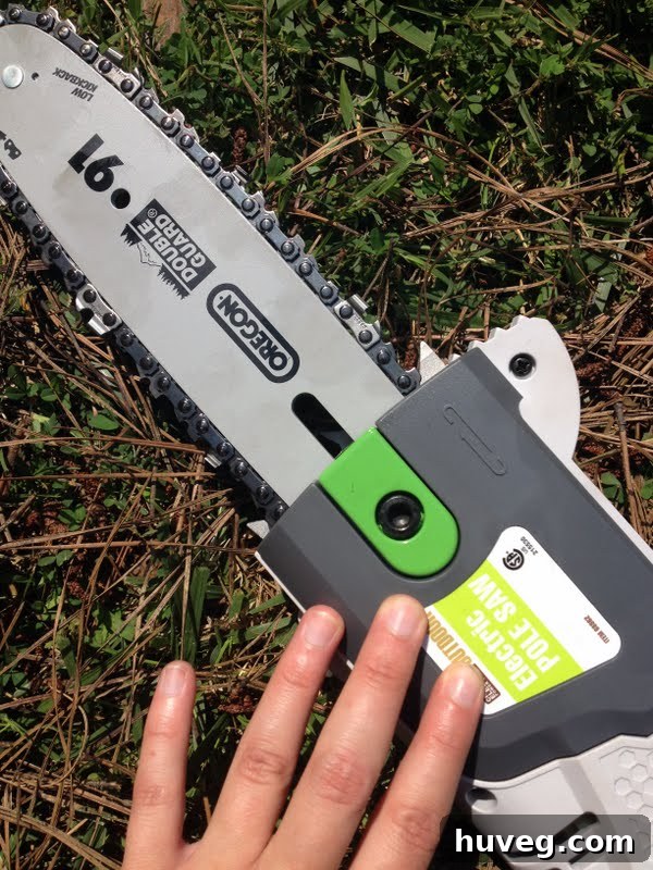 A person carefully using a pole saw to cut a tree branch, demonstrating safe trimming practices.
