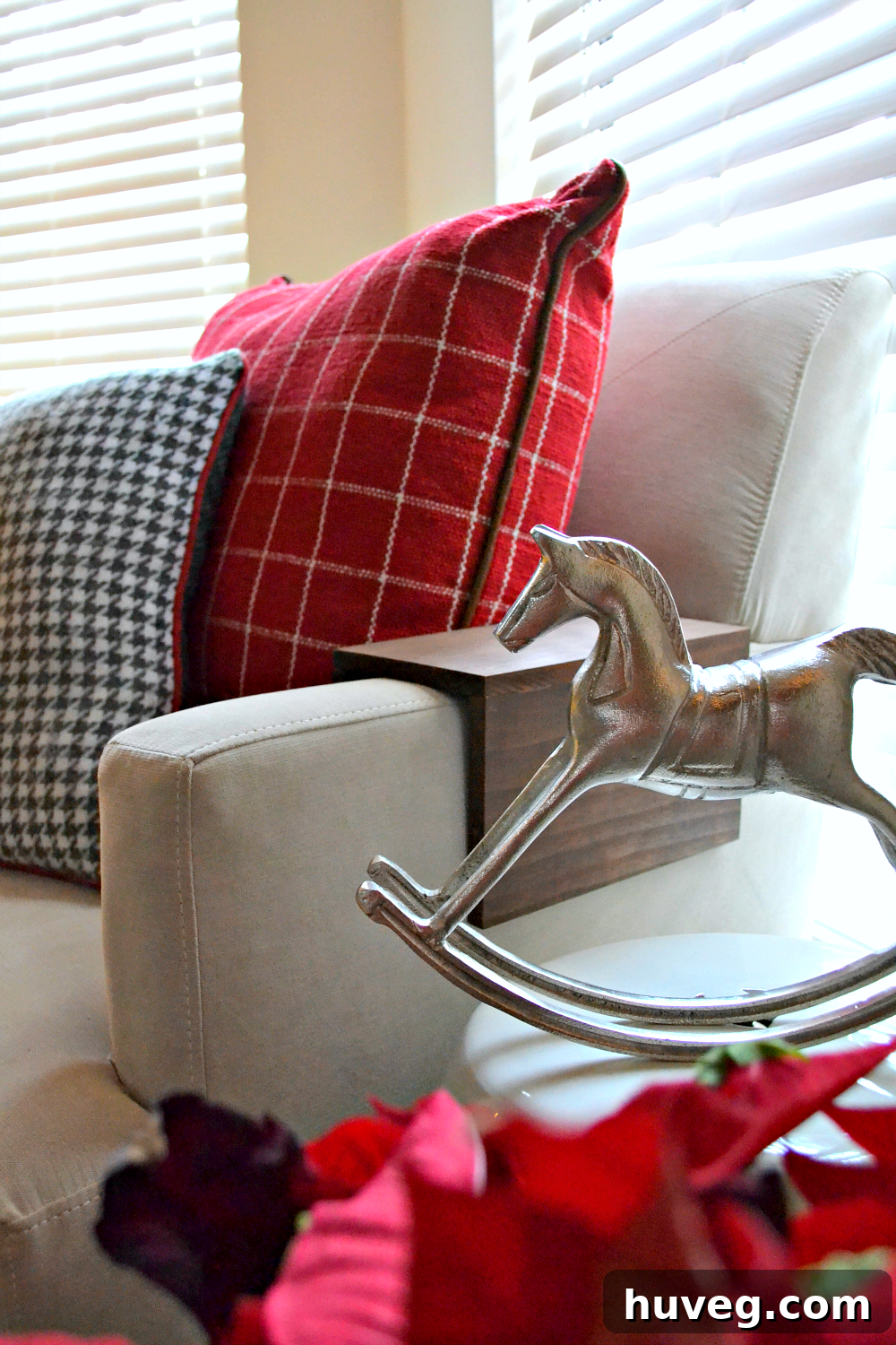 christmas pillows on sofa with a decorative horse figurine