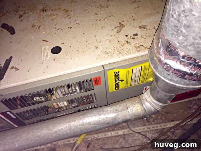 View of a dirty furnace unit located in a cramped attic space, highlighting the challenging environment for DIY repairs.