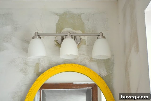 Bathroom mid-renovation showing removed fixtures and wall ready for work