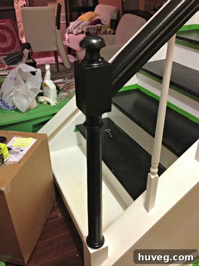 Newel post painted black with white base
