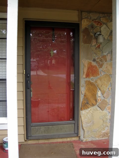 Old front door before renovation, showing an outdated and unattractive storm door