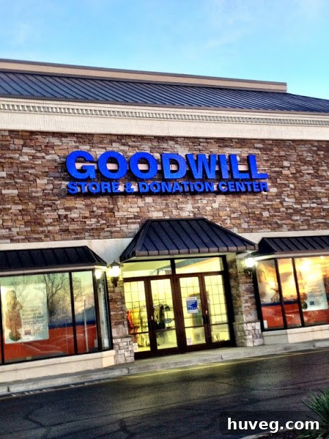 Woman holding up a sweater in a Goodwill thrift shop, 'poppin' tags'