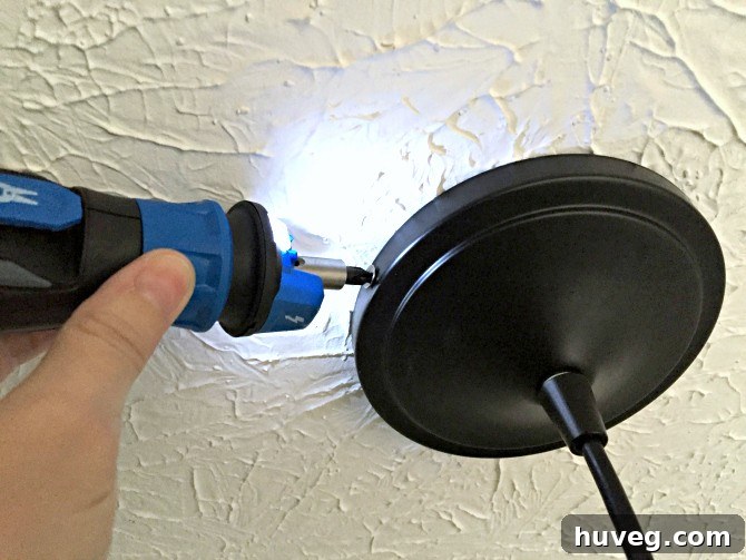 Screwing Light Canopy into Place with Cordless Screwdriver