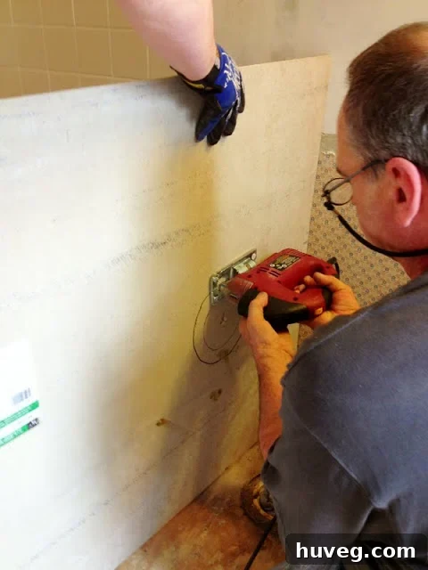 Jigsaw in action, cutting out the marked circular opening for the toilet flange in the hardibacker.