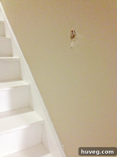Hole in the wall where the handrail was previously ripped out, awaiting reinstallation