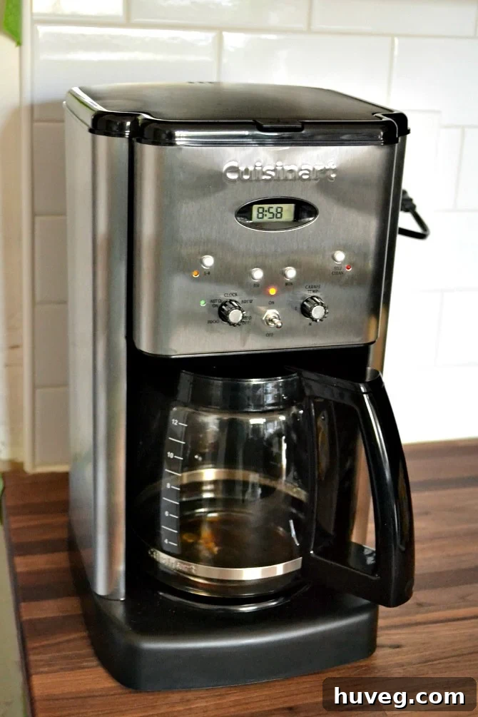 Essential coffee maker on a counter, brewing a fresh pot to start the day, symbolizing comfort and energy.