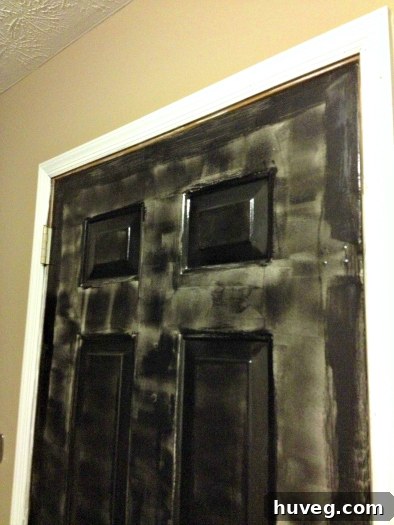 Another view of the partially painted door, emphasizing the poor quality and the need for multiple future coats to achieve a smooth, glossy finish.